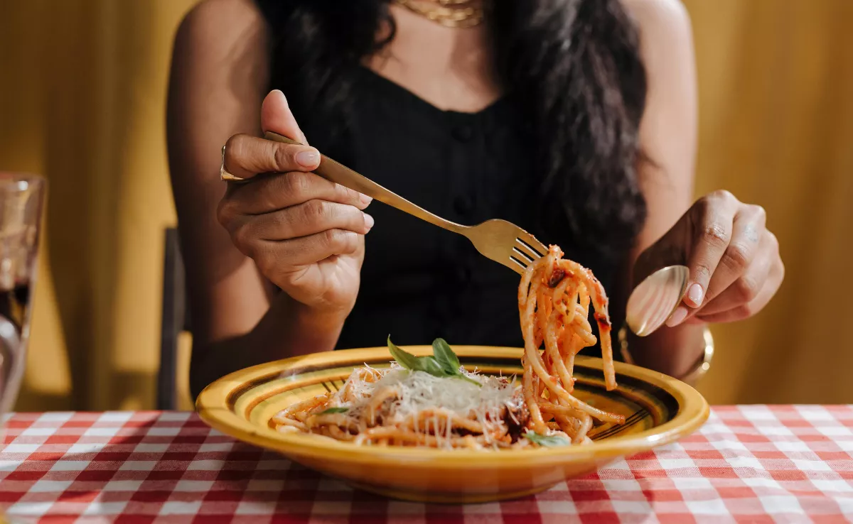 Imagen de una persona comiendo en un restaurante italiano / PEXELS
