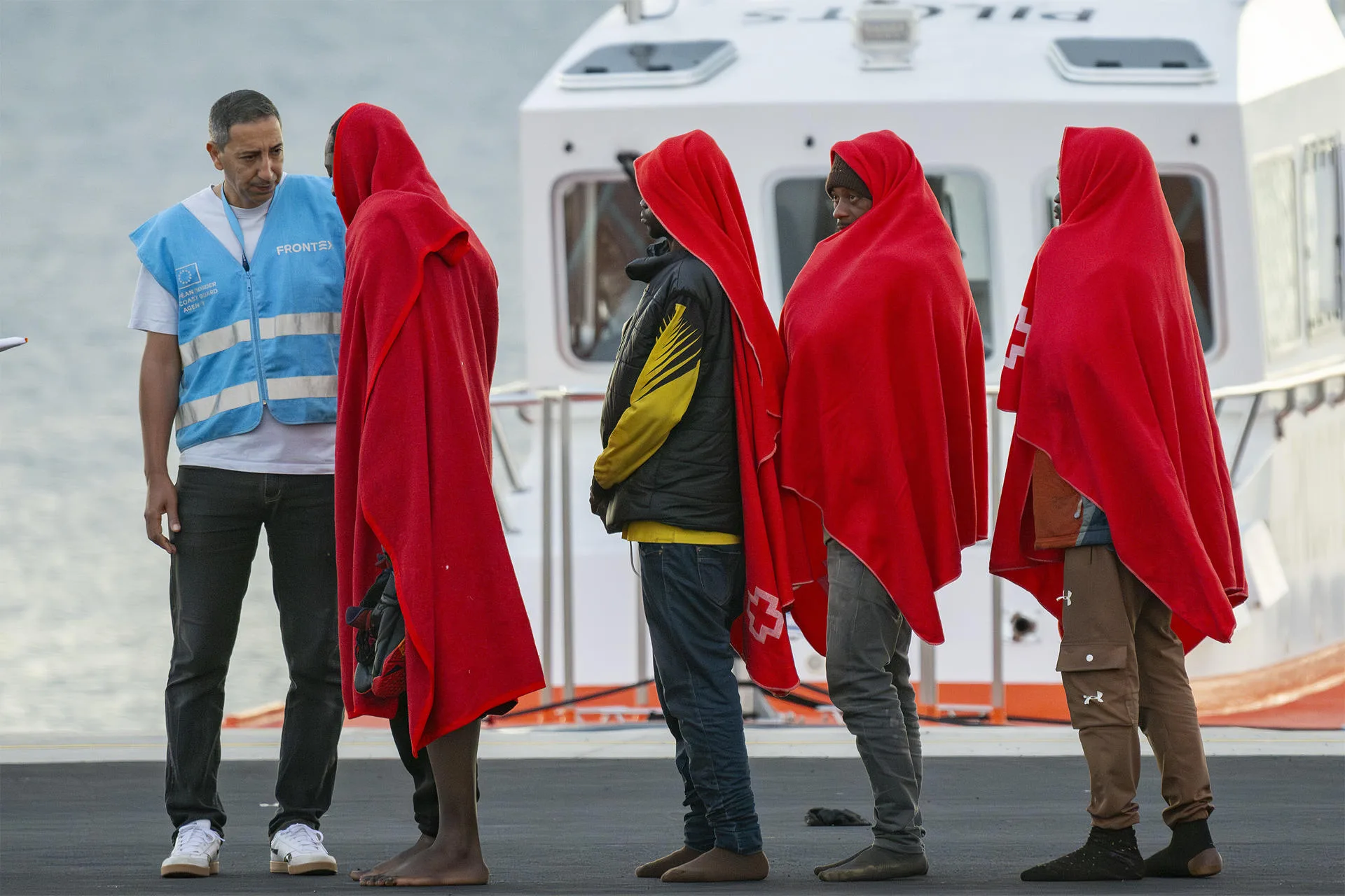 Un agente de la Agencia Europea de Fronteras y Costas (Frontex) con migrantes. / EFE - ADRIEL PERDOMO