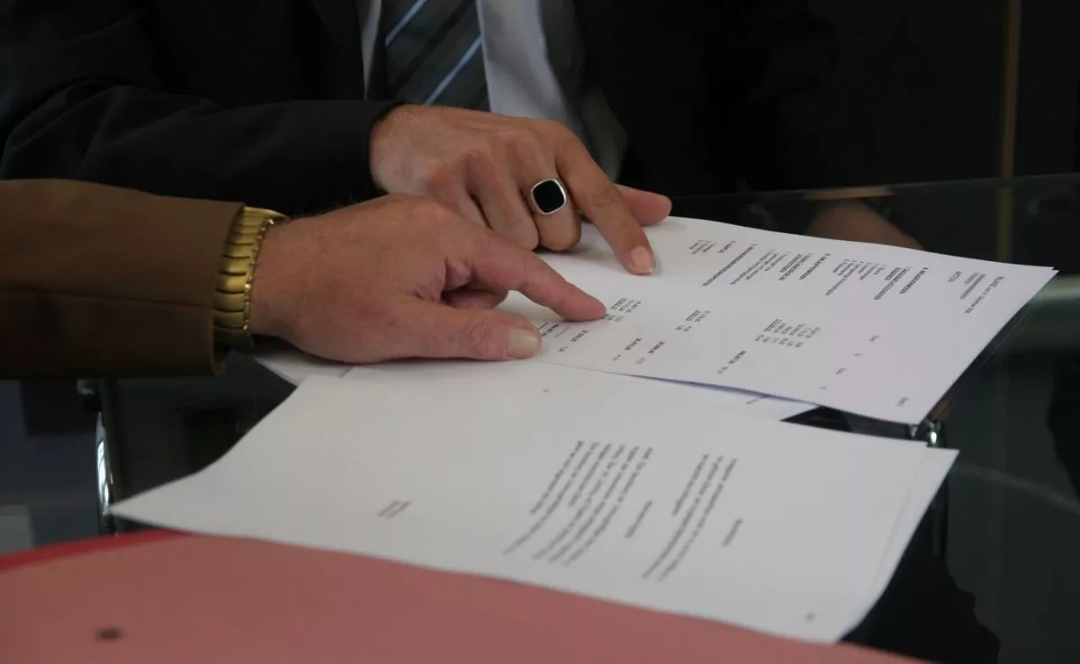 Dos personas firmando documentos. /PxHere