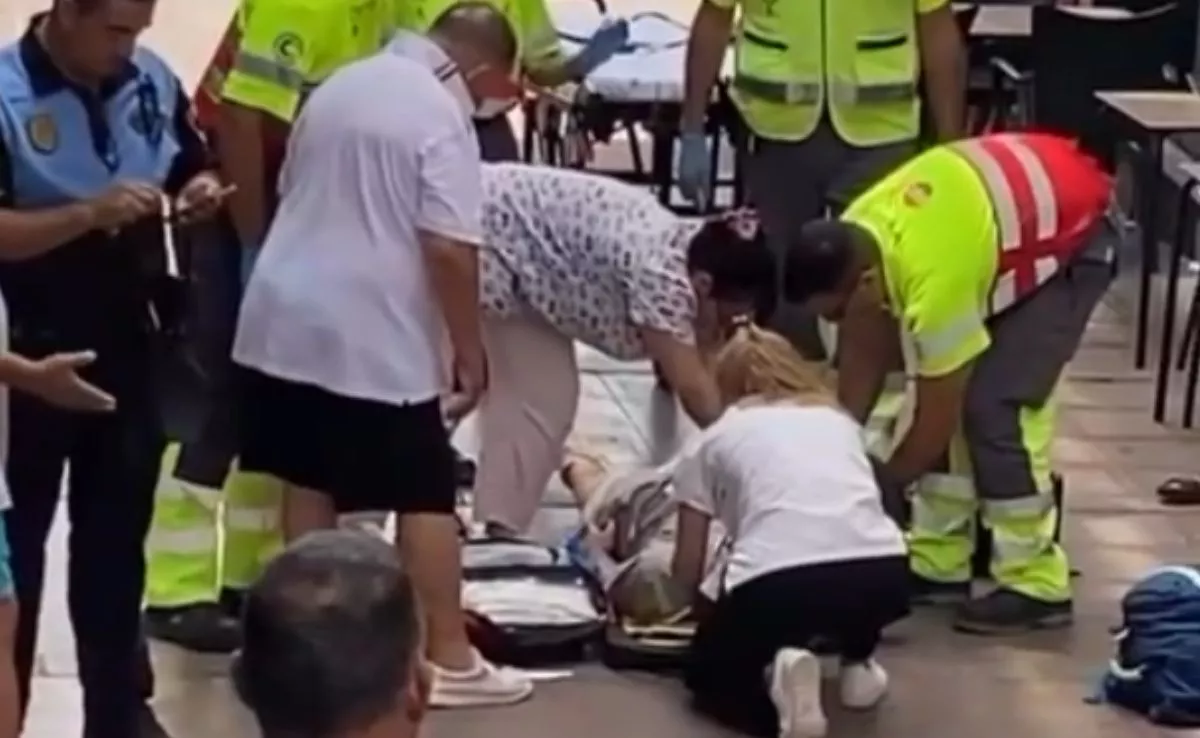 Servicios de Emergencia, Policía Local y ciudadanos atendiendo al hombre herido en Los Cristianos tras caerle encima parte de un conducto de ventilación. /Redes