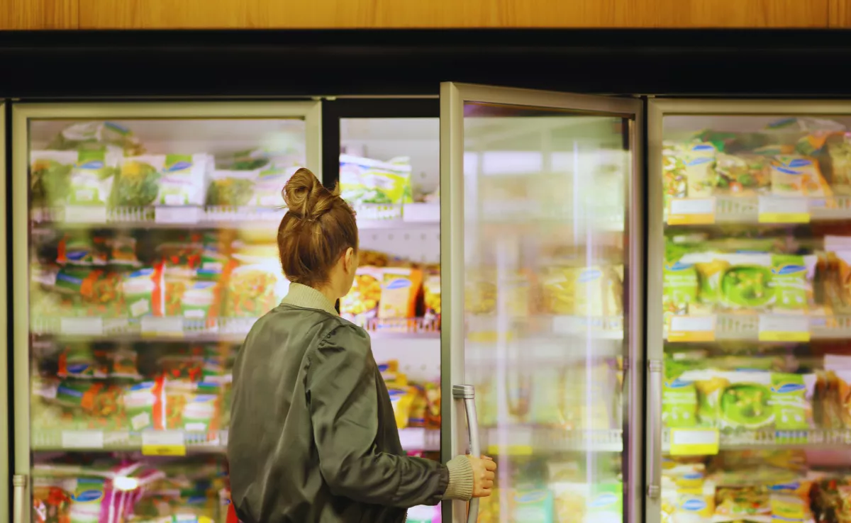 Imagen de una consumidora cogiendo congelados, entre ellos el pollo. / CANVA