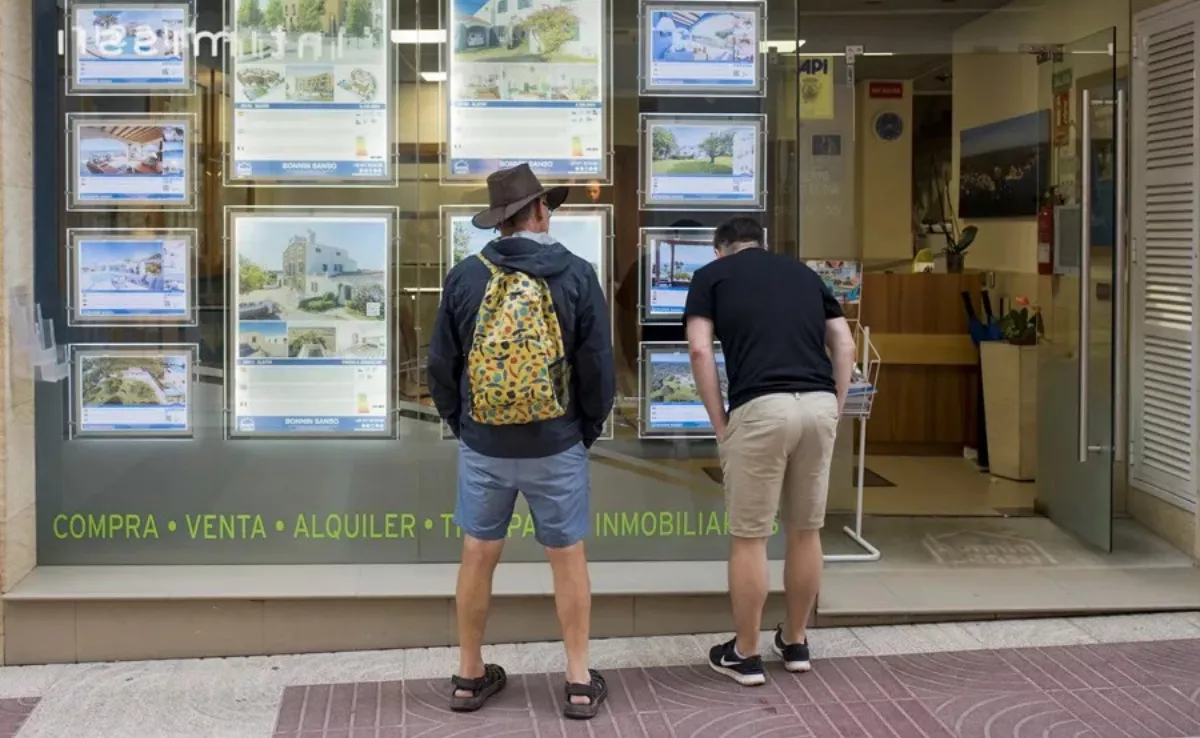 Personas mirando en el escaparate de una inmobiliaria / EFE