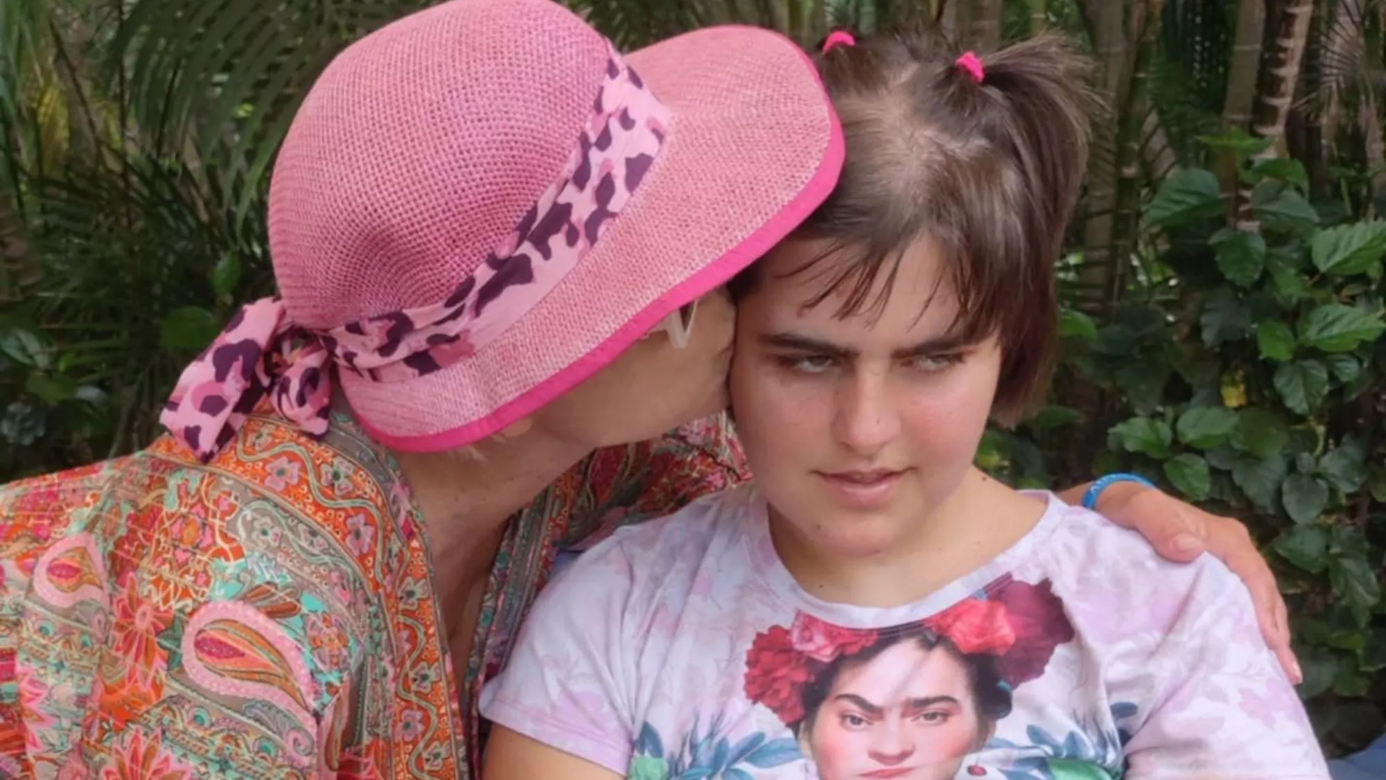 Alexandra Delgado da un beso a su hija, quien lleva más de un año esperando una resolución que le garantice una plaza alojativa por tener autismo. / CEDIDA