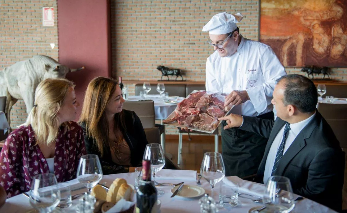 Un cocinero de Brunelli's muestra a los clientes la carne que van a comer./ BRUNELLI'S