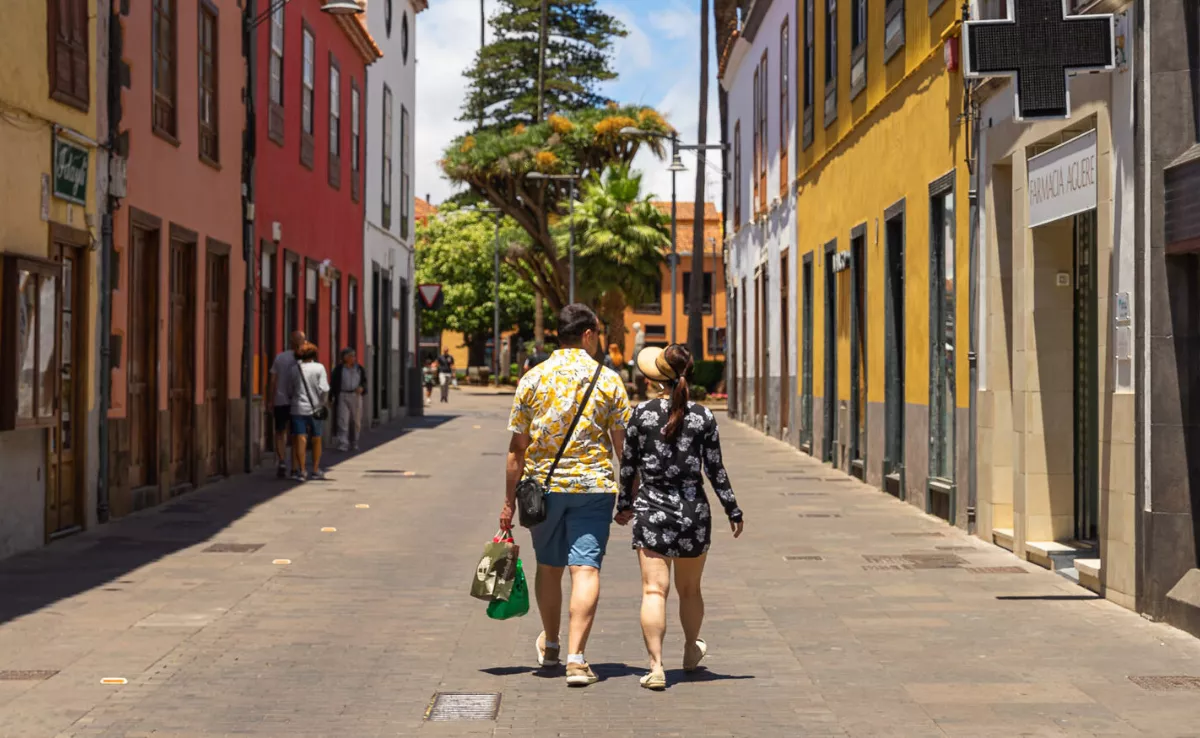 Dos personas que compran en comercios locales de La Laguna pasean por las calles del municipio./ LA LAGUNA COMERCIAL