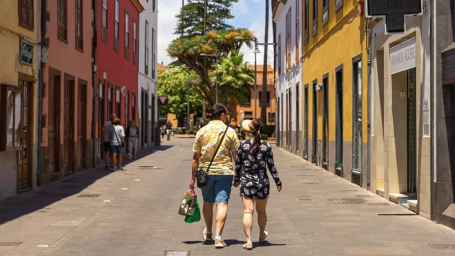Dos personas que compran en comercios locales de La Laguna pasean por las calles del municipio./ LA LAGUNA COMERCIAL