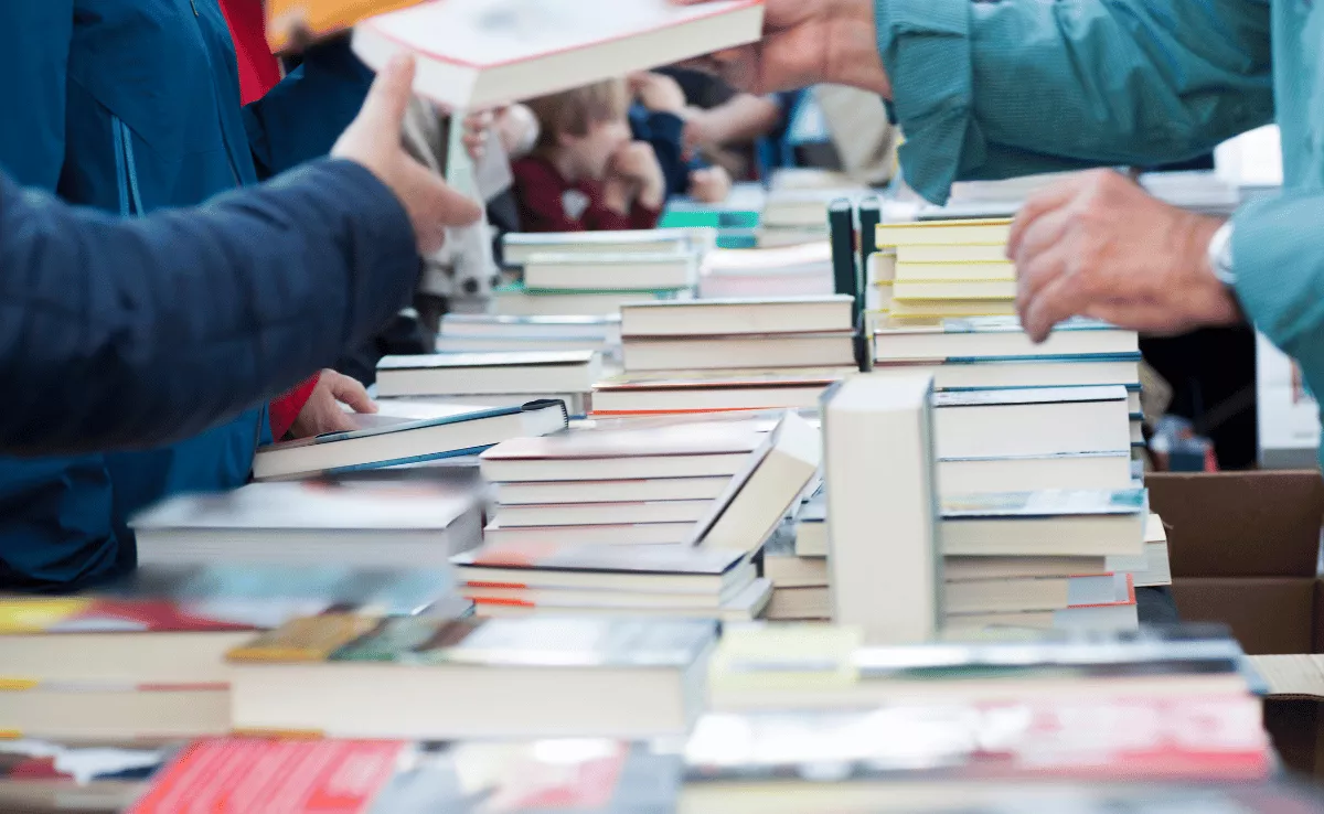 Imagen de un grupo de personas en una feria del libro / CANVA