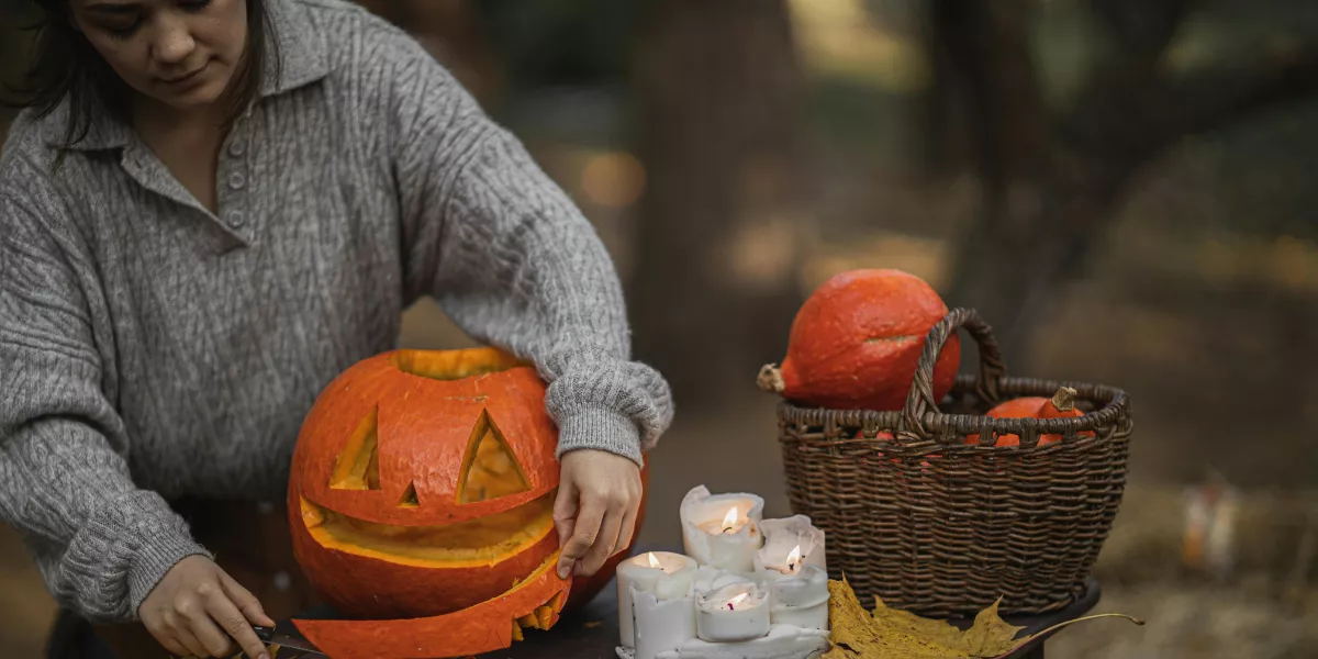Imagen de una persona con una calabaza en Halloween / PEXELS