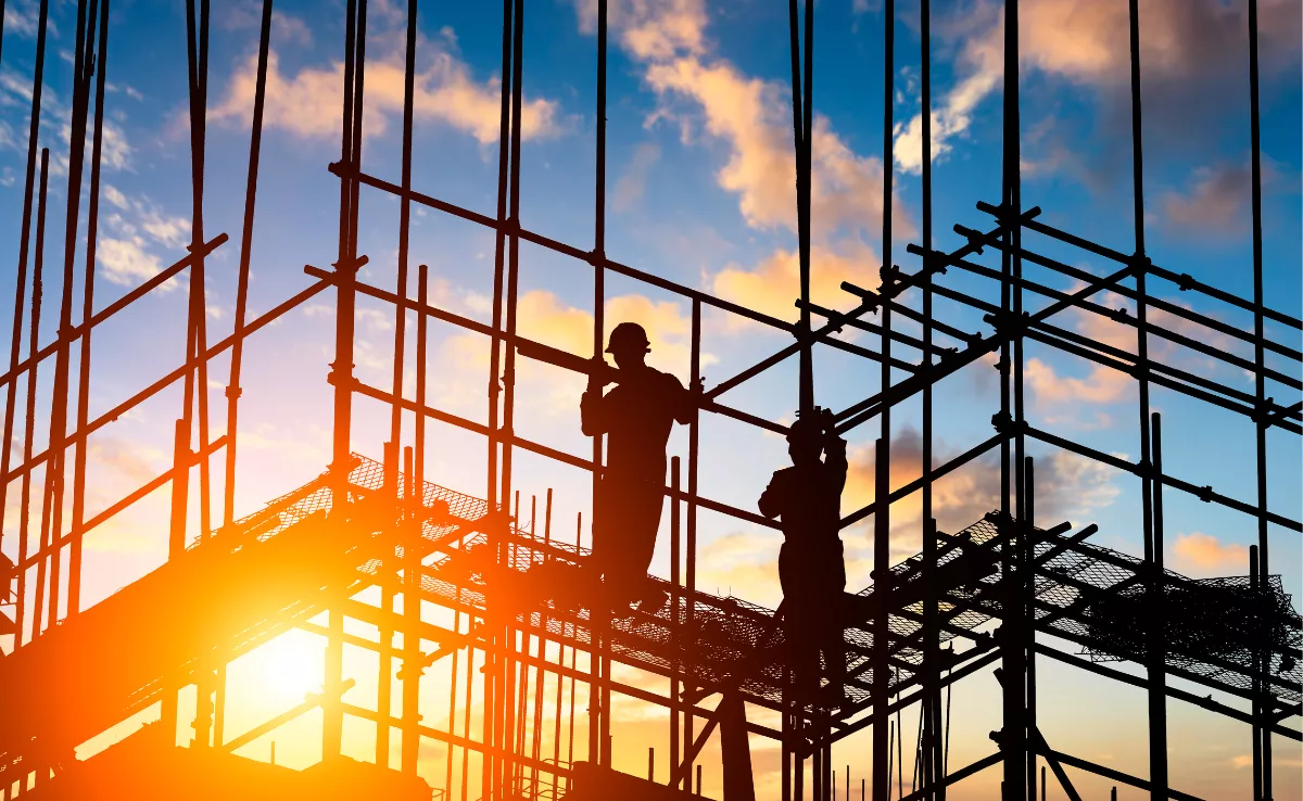 Imagen de unos obreros construyendo viviendas / CANVA