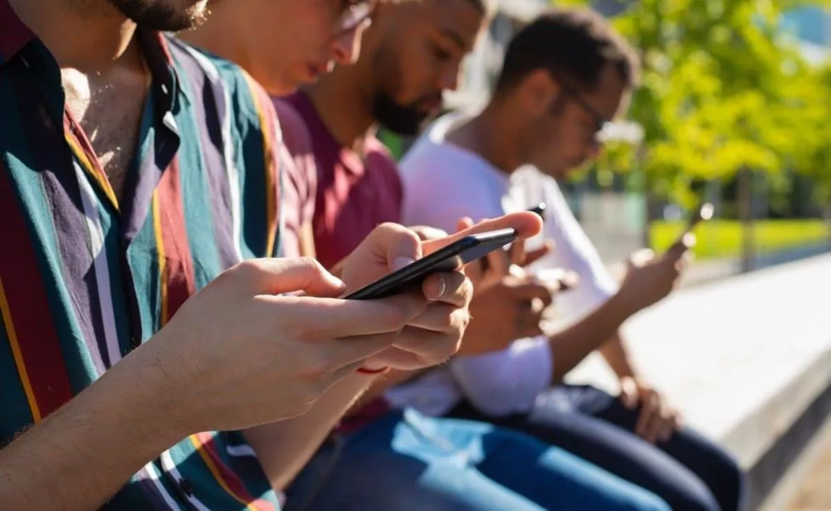 Grupo de jóvenes mirando el móvil. /Archivo