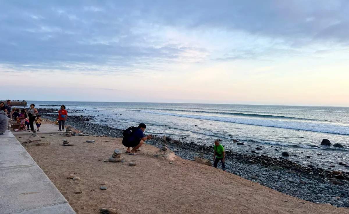 Un turista fotografía piedras amontonadas en el paseo del Faro de Maspalomas / ATLÁNTICO HOY - MARCOS MORENO
