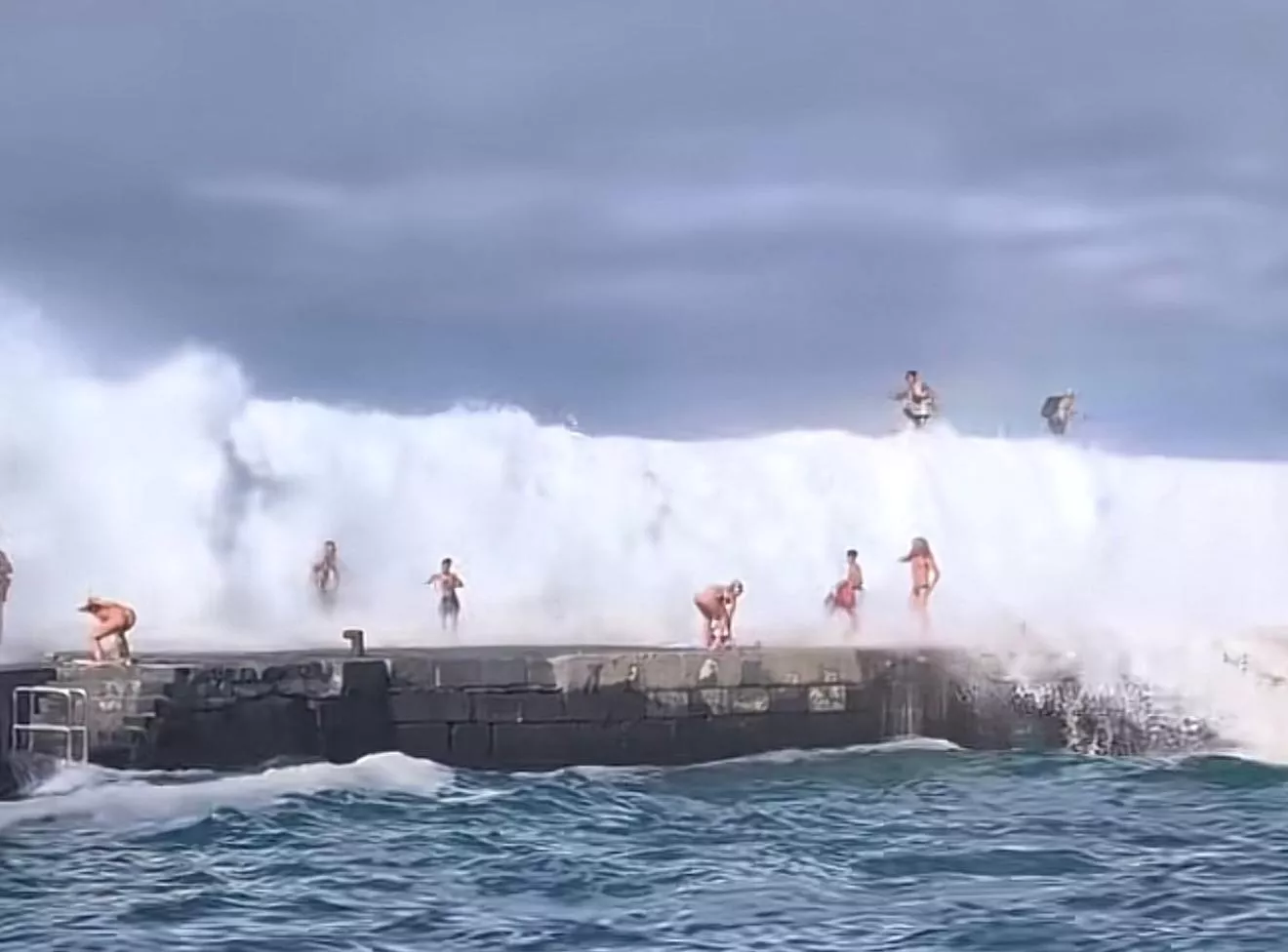 Imagen de personas sorprendidas por las olas en Puerto de la Cruz. / REDES