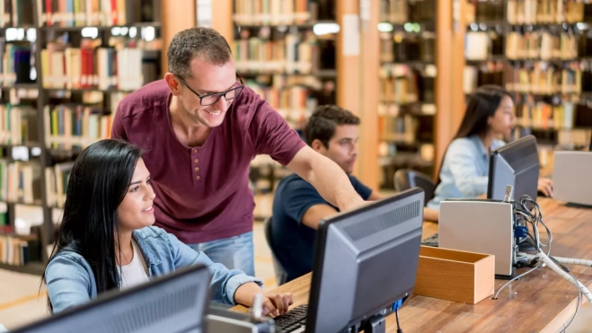 Imagen de un bibliotecario ayudando a unos estudiantes / CANVA Imagen de un bibliotecario ayudando a unos estudiantes / CANVA