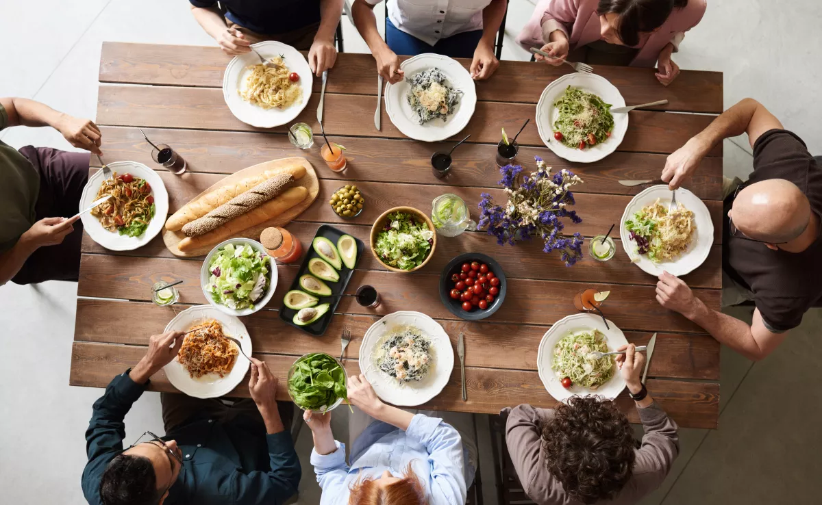 Imagen de un grupo de personas comiendo / CANVA