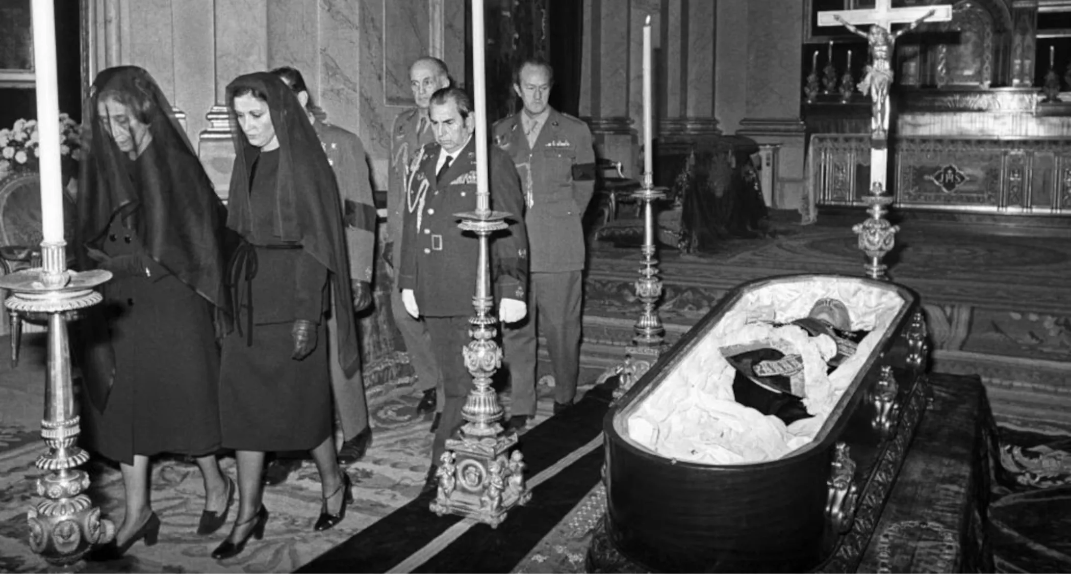 El féretro con los restos mortales de Franco durante uno de los funerales, en la iglesia de El Pardo, antes de ser trasladado al Palacio Real. A la izquierda su viuda, Carmen Polo, y su hija, la marquesa de Villaverde.. / EFE