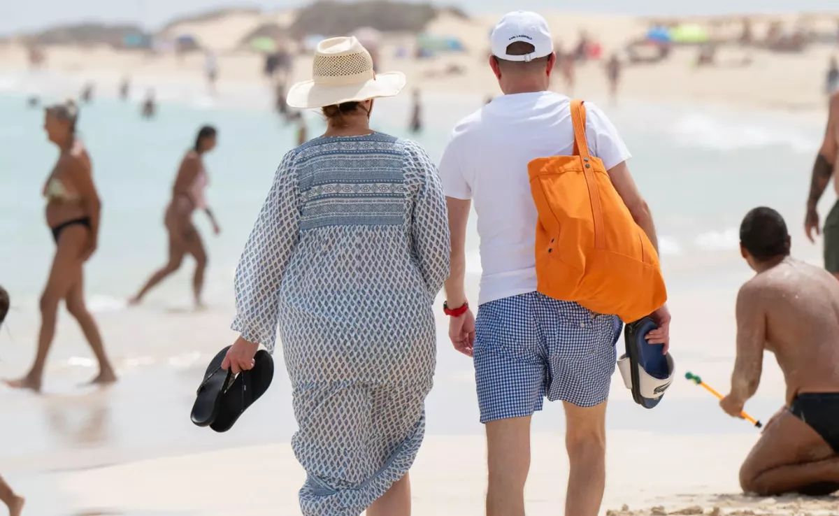 Imagen de unos turistas paseando por una playa de Canarias / EFE