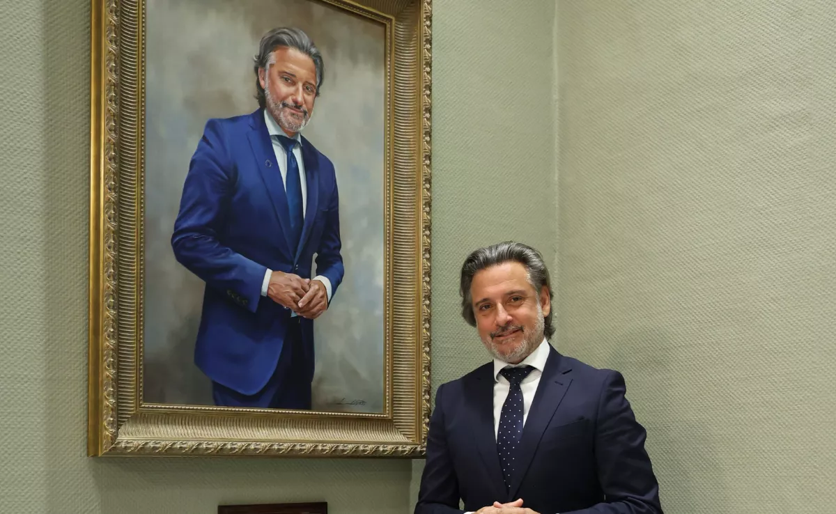 El expresidente del Parlamento de Canarias Gustavo Matos junto a su retrato. / CEDIDA