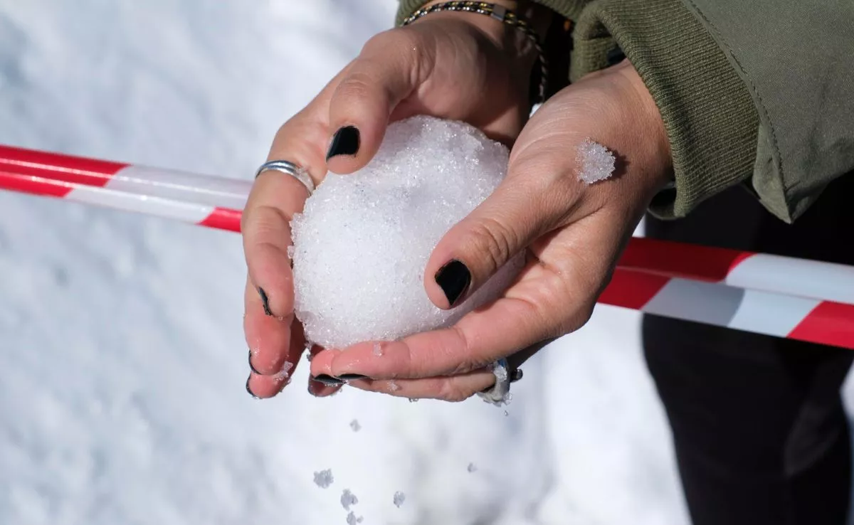 Persona haciendo una bola de nieve en el Teide después de la borrasca Emilia. /EFE / Alberto Valdés