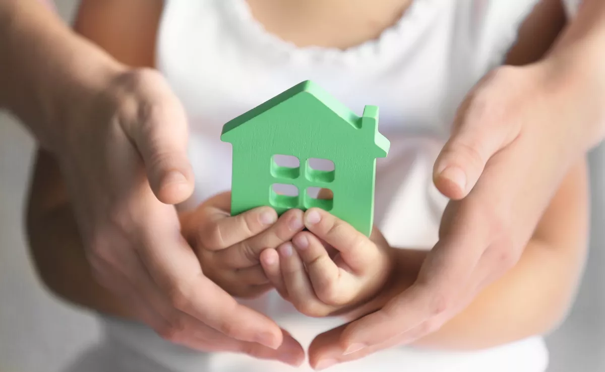 Un menor sostiene una figura de un hogar. / IMAGEN DE LA RED