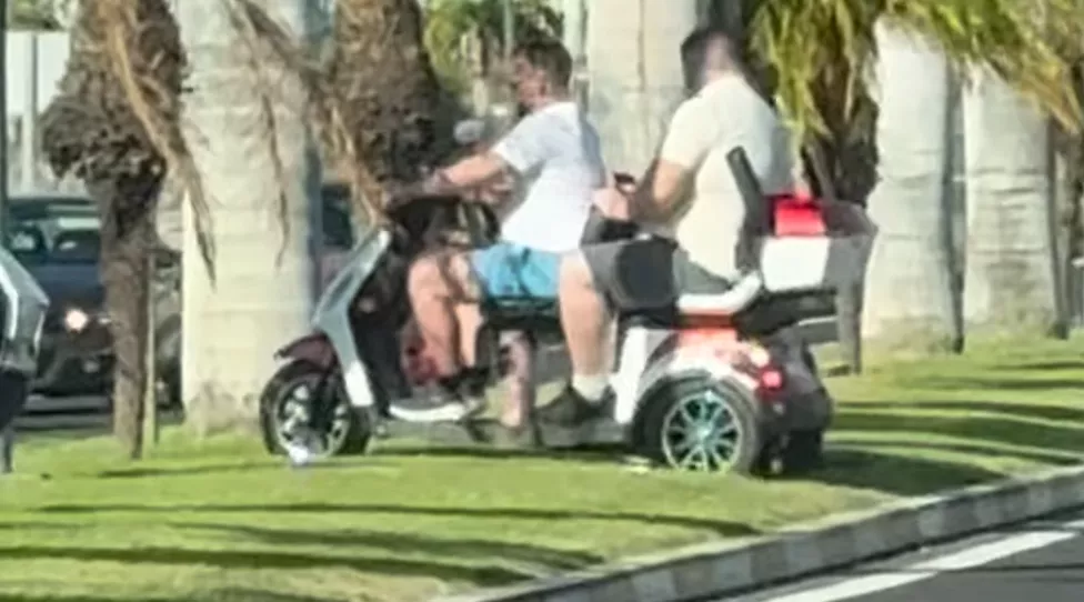 Unos turistas cruzando la mediana en Los Cristianos con scooters eléctricas. / Andreykrivashov