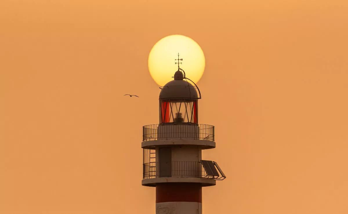 Un faro con sol de fondo durante un episodio de Calima. /Eduardo Robaina