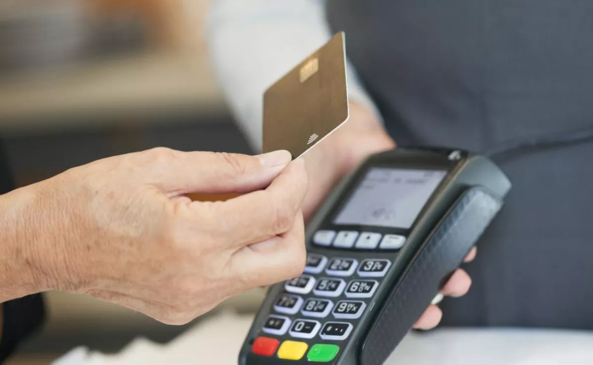 Una persona pagando con tarjeta / GETTY