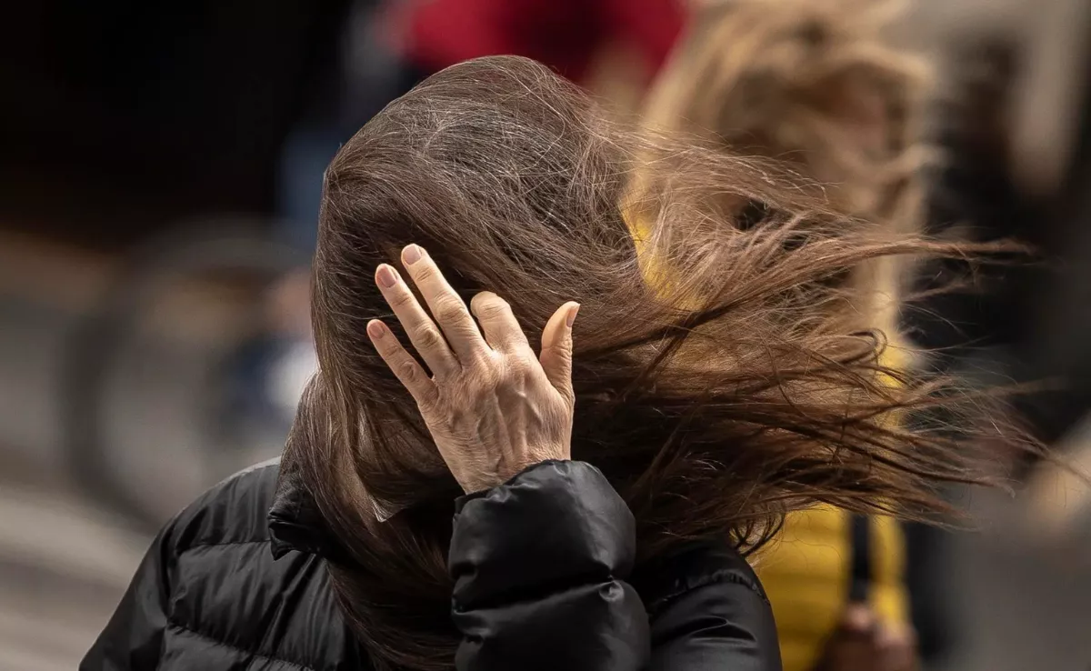 Una mujer se quita el pelo de la cara por el viento / EFE