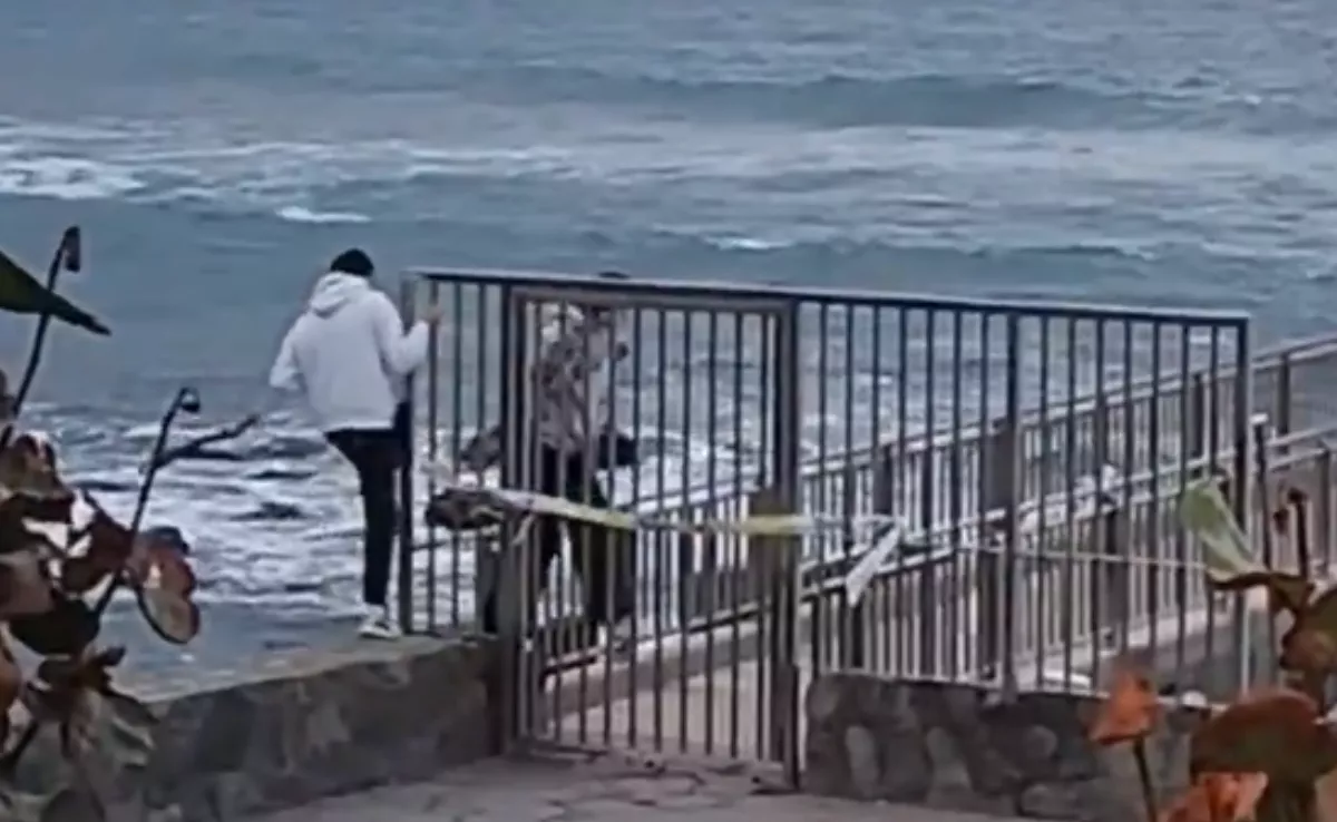 Dos personas saltan el vallado de seguridad en una playa de Tenerife con acceso restringido. / AYUNTAMIENTO DE SANTA CRUZ DE TENERIFE