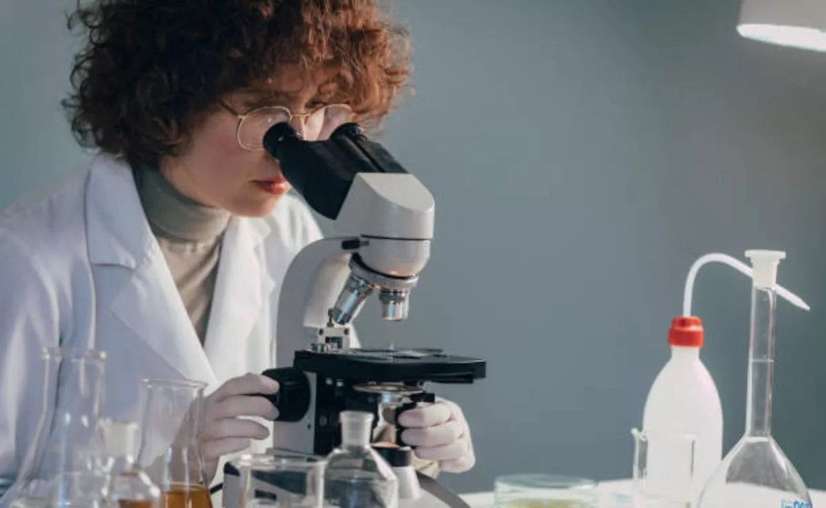 Mujer científica con un microscopio. /Pexels