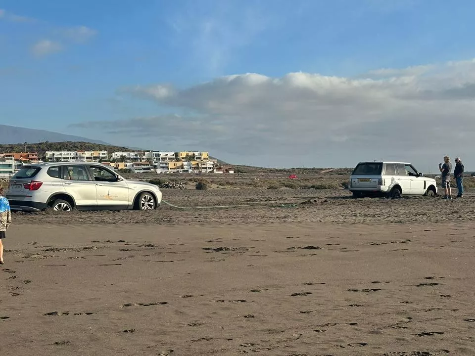 Dos vehículos atrapados en la arena de La Tejita al intentar sacar un velero varado./ FELIX TRUJULLO Dos vehículos atrapados en la arena de La Tejita al intentar sacar un velero varado./ FELIX TRUJULLO