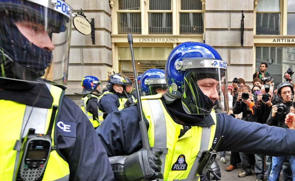 Un agente antidisturbios con una porra o bastón extensible durante una protesta. / REDES