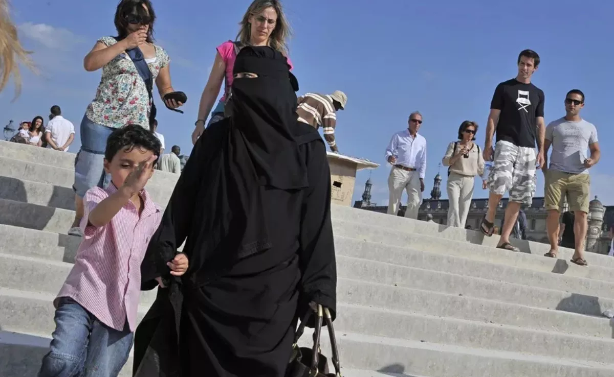 Una mujer cubierta con un nicab acompañada de un niño. EFE/Horacio Villalobos