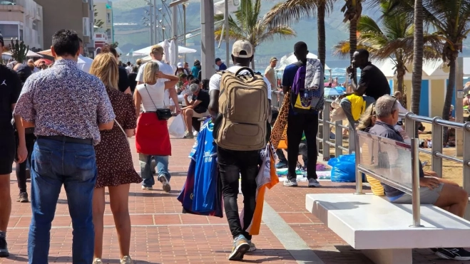 Un vendedor ambulante de prendas deportivas falsas a plena hora punta de un domingo. ALBERTO LEY