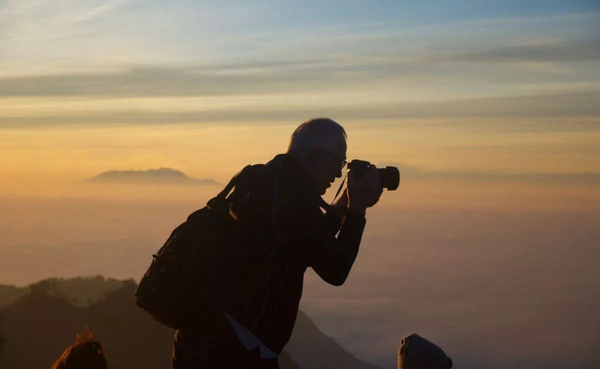 Turista sacando una foto al atardecer. /PxHere