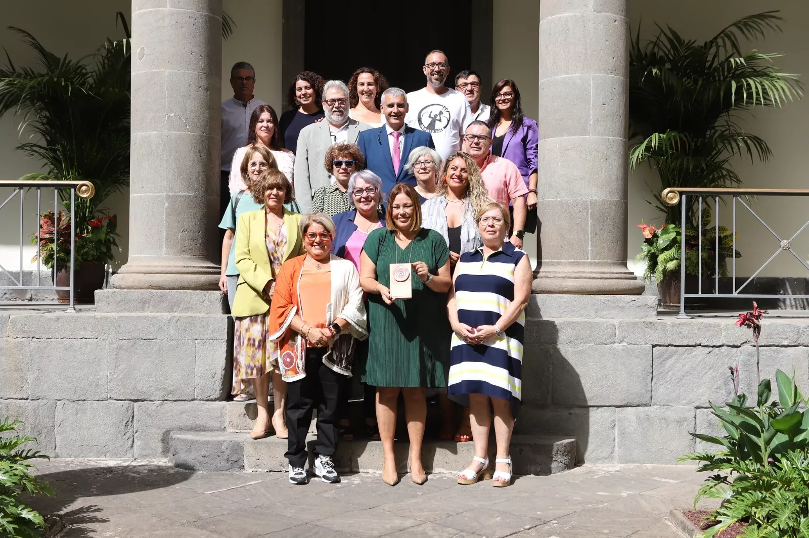 La presidenta del Parlamento de Canarias, Astrid Pérez, con representantes de Atelsam, quienes regalaron una placa de madera. / PARLAMENTO DE CANARIAS
