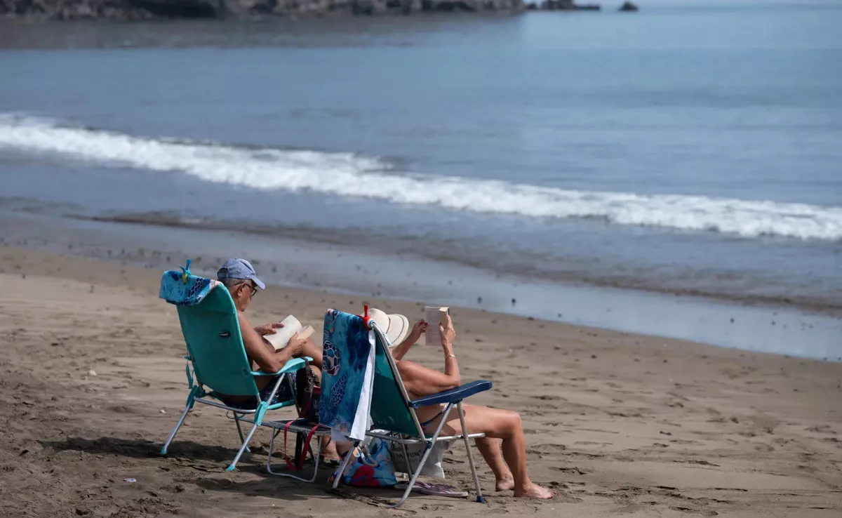 Dos turistas en la playa de Gran Tarajal (Fuerteventura) / EFE - CARLOS DE SÁA