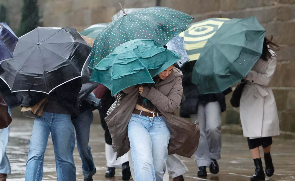 Imagen de un grupo de estudiantes de camino a clase durante un episodio de mal tiempo / EFE