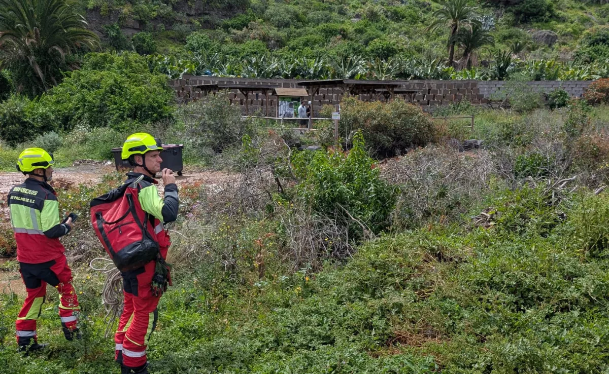 Bomberos de Las Palmas de Gran Canaria intentan rescatar a dos personas atrapadas en el barranco de Guiniguada, que pueden verse al fondo de la imagen./ CEDIDA