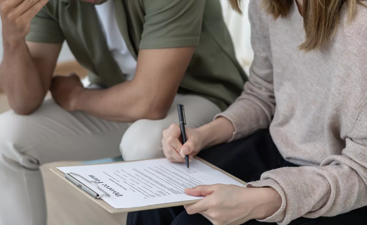 Imagen de una pareja firmando el divorcio / CANVA