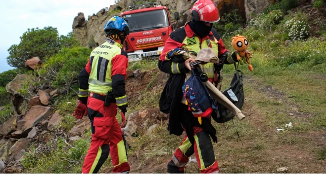 Efectivos de emergencias sacan objetos personales de la guagua / EFE - ALBERTO VALDÉS