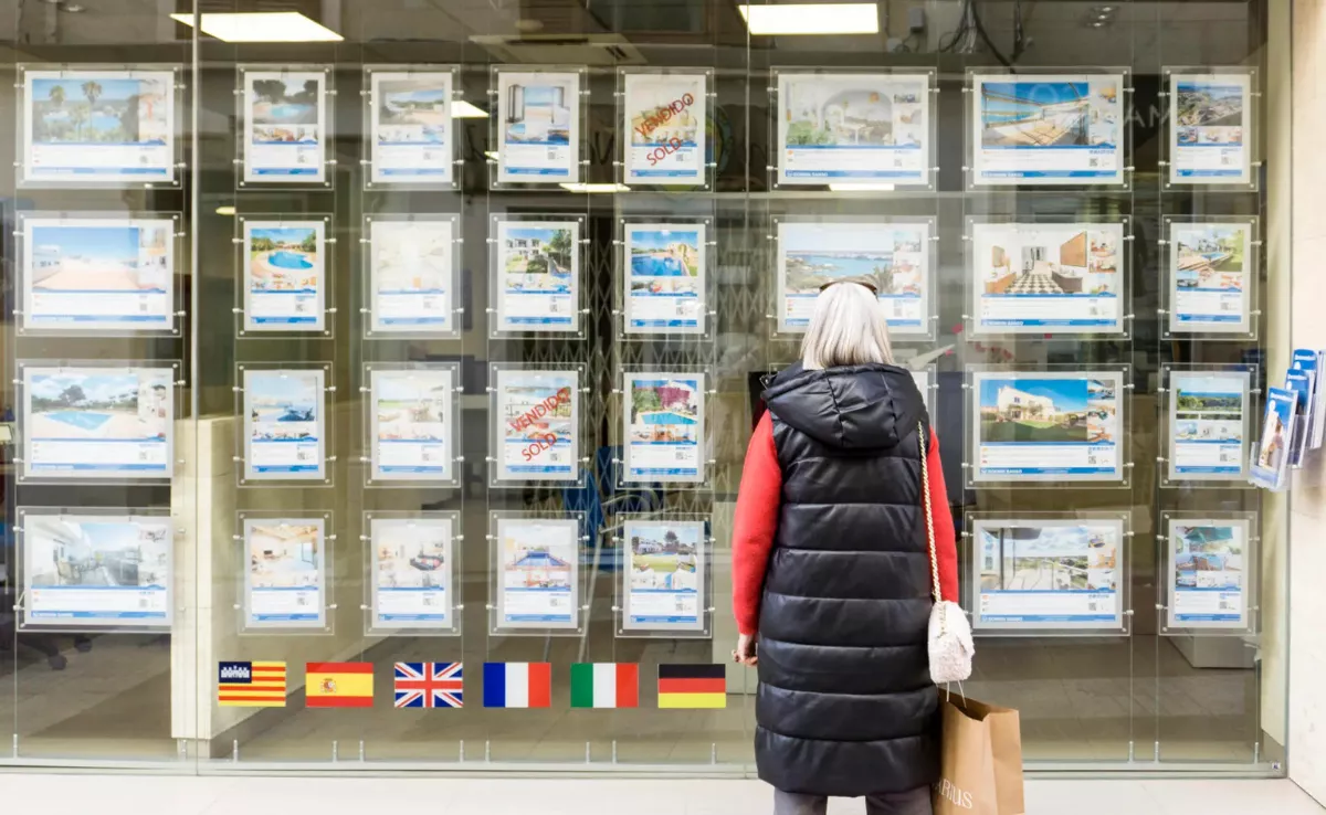 Una persona mira el escaparate de una inmobiliaria / EFE