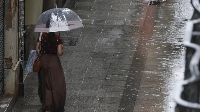 Imagen de una persona caminando bajo la lluvia / EFE