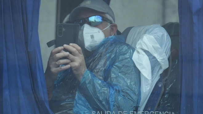 Uno de los evacuados del ‘MV Hondius’ fotografía con su móvil el operativo en Granadilla. / MIGUEL BARRETO-EFE