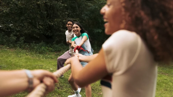Imagen de niños y niñas jugando en un campamento de verano / CANVA