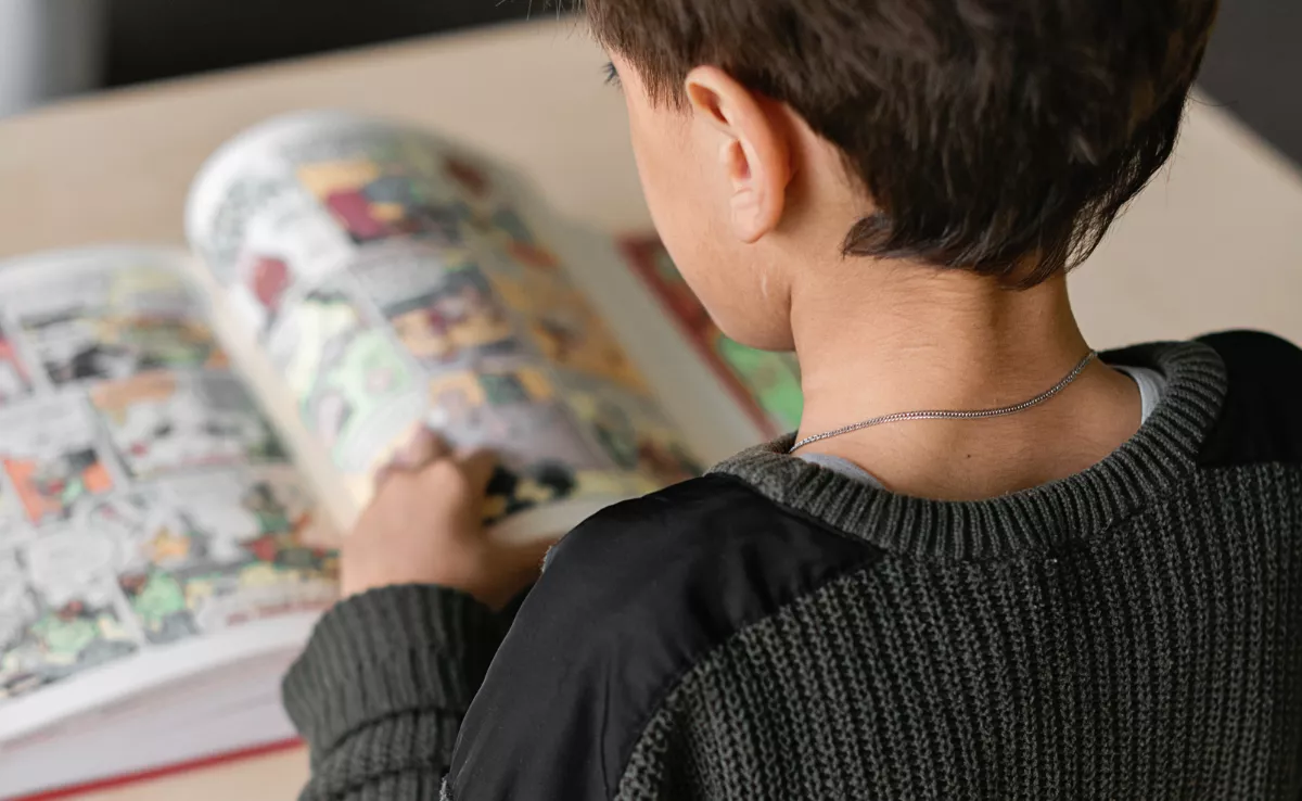 Imagen de un niño leyendo un cómic / CANVA