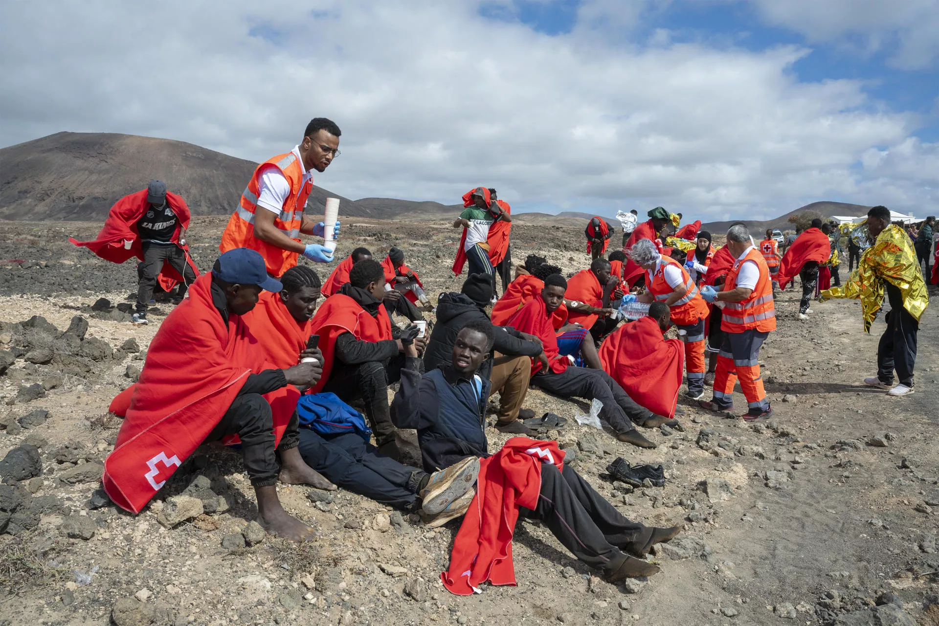 Momento de la atención humanitaria de Cruz Roja las 50 personas  que llegaron en una neumática hasta Punta del Banquete, en el municipio de Teguise. / ADRIEL PERDOMO-EFE
