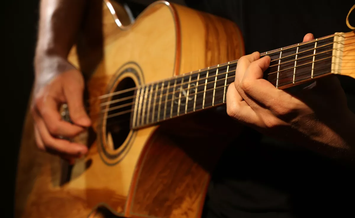 Imagen de una persona tocando la guitarra / CANVA