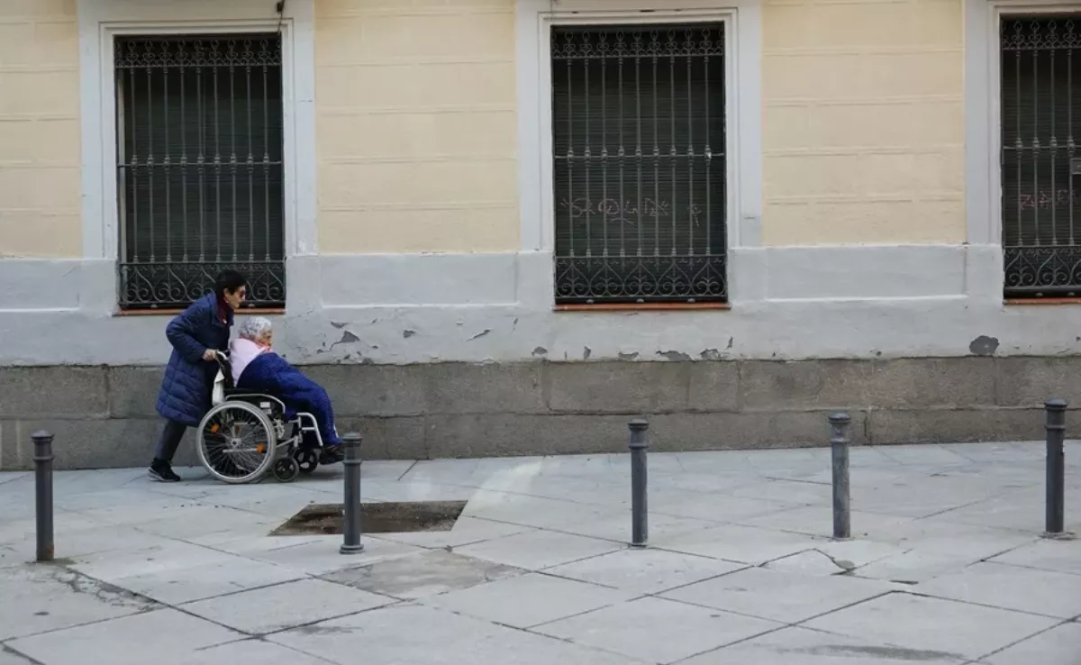 Imagen de una persona paseando a otra en silla de ruedas / EFE