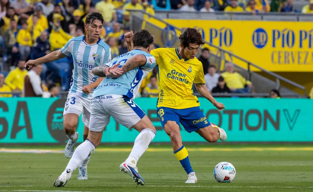 El defensa del Málaga Diego Murillo (c) disputa un balón con el delantero de Las Palmas Taisei Miyashiro (d) / QUIQUE CURBELO - EFE