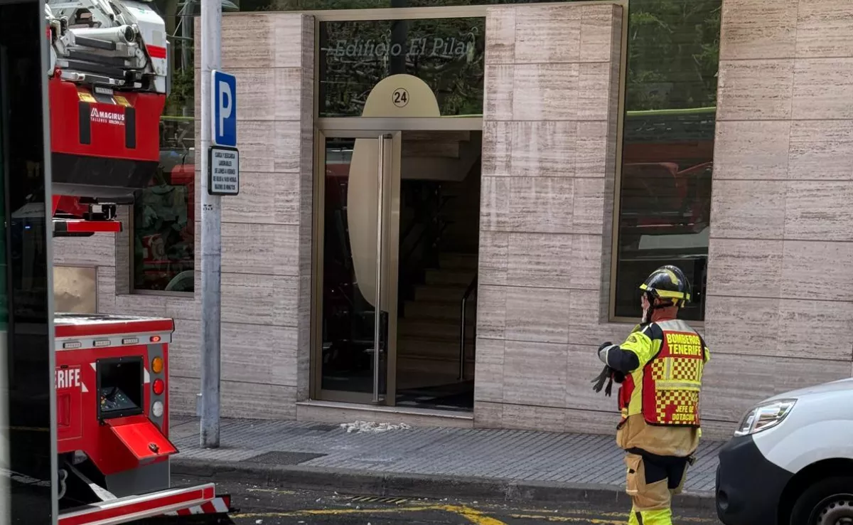 Los bomberos aseguran el edificio El Pilar de Santa Cruz tras caer una baldosa de la fachada en la puerta desde una altura de cuatro pisos./ AH